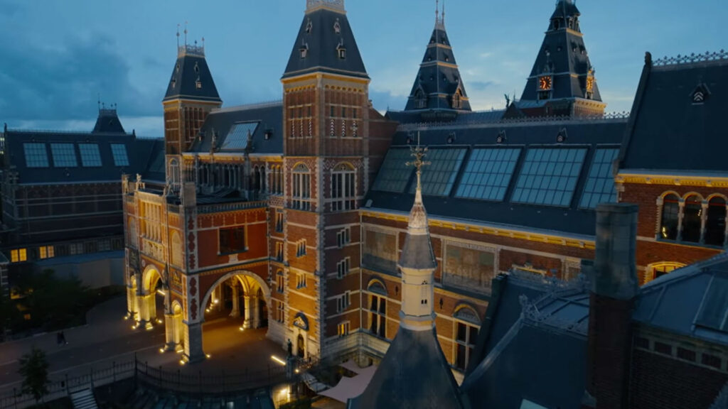 Dronebeeld van het Rijksmuseum in Amsterdam bij avondlicht