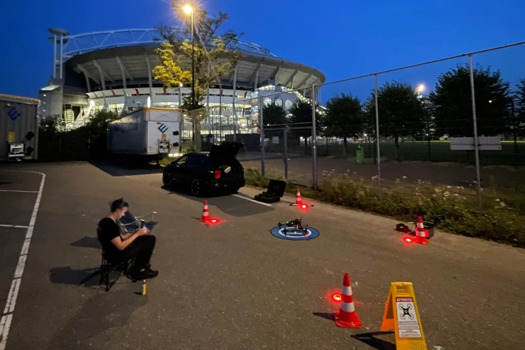Dronepiloot bij de startplaats naast het stadion in de avond