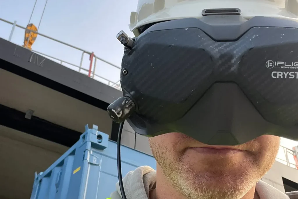 FPV-dronepiloot met goggles op een bouwplaats