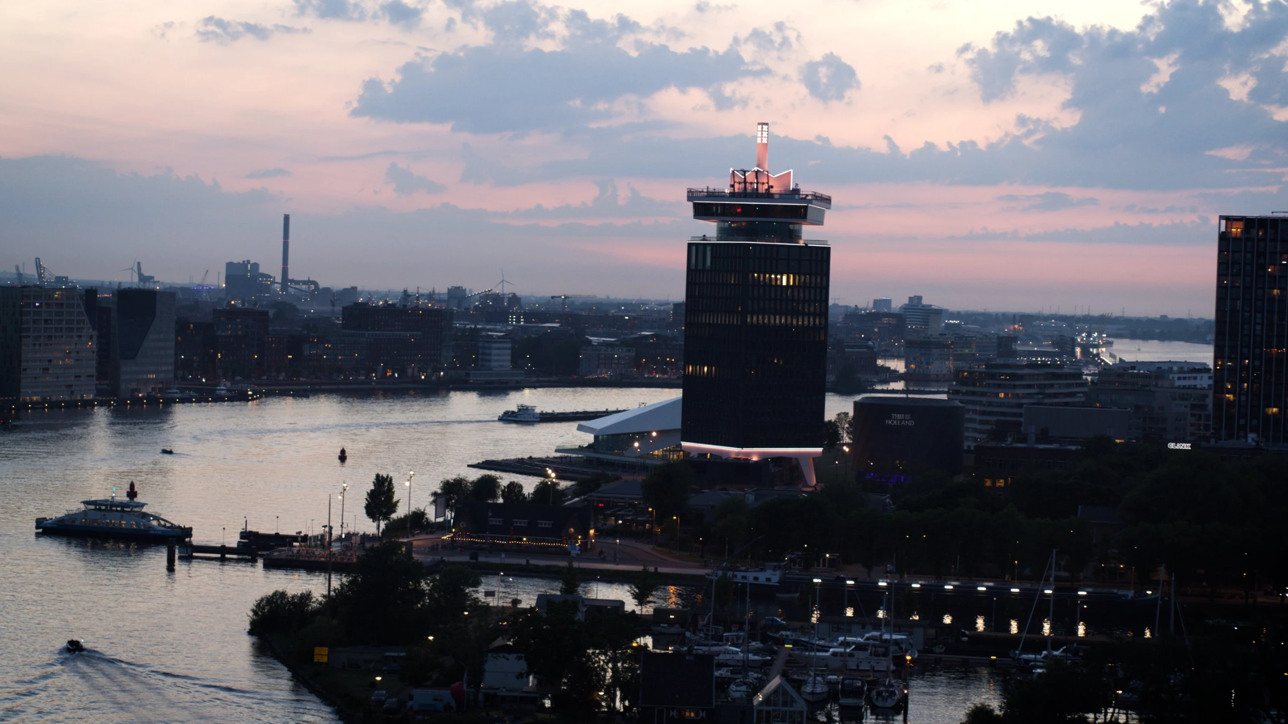 Dronefoto van de A'DAM Toren en het IJ in Amsterdam bij schemering