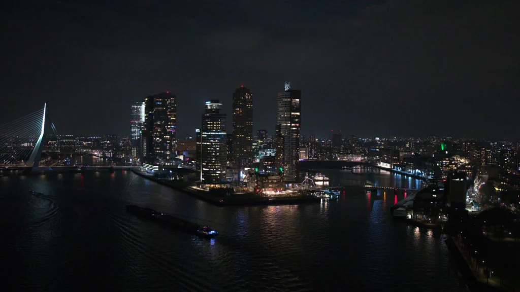 Dronefoto van de Kop van Zuid in Rotterdam in de nacht, buiten de UDP