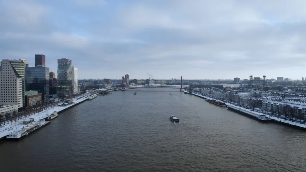 Dronefoto van de Maas en de Willemsbrug in Rotterdam in de sneeuw
